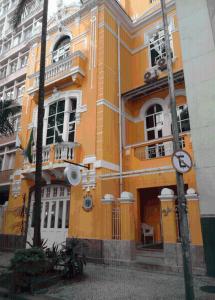 un edificio amarillo con una puerta en una ciudad en Hotel Venezuela, en Río de Janeiro