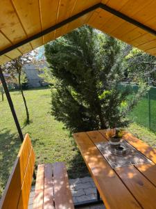 een houten picknicktafel en bank in een tuin bij Oreo Apartman in Eger