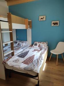 sypialnia z łóżkiem piętrowym i krzesłem w obiekcie L'échappée Belle en Montagne w mieście Mieussy