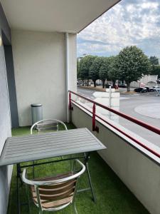 einen Picknicktisch und zwei Stühle auf dem Balkon in der Unterkunft Charmant appartement la Roche sur Yon in La Roche-sur-Yon