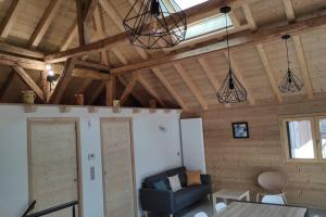 una sala de estar con paredes de madera y techos de madera. en L'échappée Belle en Montagne, en Mieussy