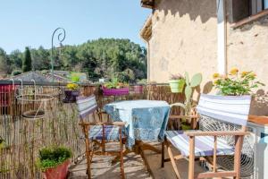 d'une terrasse avec une table, des chaises et une clôture. dans l'établissement Aude en Provence, à Meyrargues