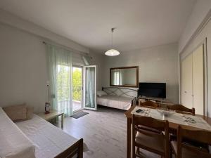 a bedroom with a bed and a table and a television at Kiki's house Afytos in Afitos