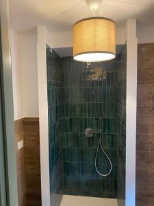 La salle de bains est pourvue d'une douche et d'un mur carrelé vert. dans l'établissement A Casa del Console apartment, à Manfredonia