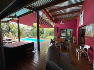 uma sala de estar e de jantar com uma parede cor-de-rosa em Ti Koin Trankil Belle & spacieuse villa tropicale em Saint-Pierre