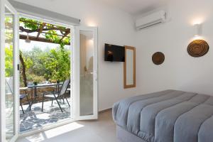 1 dormitorio con 1 cama y balcón con mesa en Aegean Harmony, en Platis Yialos Sifnos