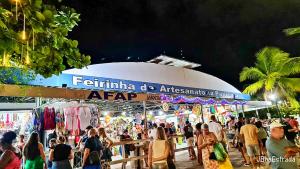 uma multidão de pessoas andando em torno de um mercado à noite em 02 QUARTOS, a 200 metros da PRAIA de PAJUÇARA em Maceió mais 41 fotografias