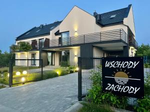 a house with a sign in front of it at WSCHODY I ZACHODY in Jastrzębia Góra