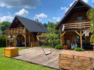 una casa con terrazza in legno con canestro da basket di Babie Domki a Zawoja