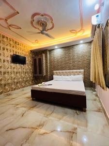 a bedroom with a bed and a tv on a wall at The Bella Guesthouse in Varanasi