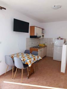a kitchen with a table and chairs in a kitchen at Apartment Lopar, Primorje-Gorski Kotar 5 in Lopar