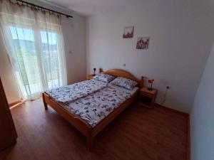 a bedroom with a bed and a large window at Apartment Lopar, Primorje-Gorski Kotar 5 in Lopar