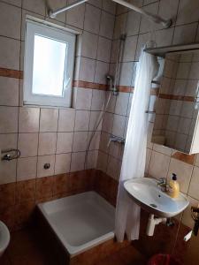 a bathroom with a tub and a sink and a shower at Apartment Lopar, Primorje-Gorski Kotar 5 in Lopar