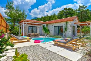 a villa with a swimming pool in a garden at Sojoy Villa Allure in Fethiye