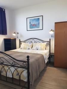 Schlafzimmer mit einem schwarzen Bett und weißen Kissen in der Unterkunft Apartment and rooms Parus in Koper