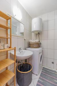 a bathroom with a sink and a washing machine at Traditional holiday house by the sea in Preko