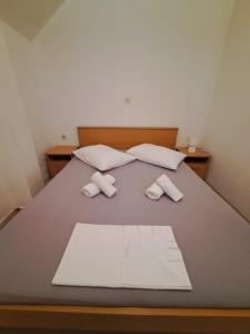 a bed with two pillows and two towels on it at Apartmani Ante 1 in Drašnice