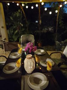 uma mesa com pratos e copos e um vaso com flores em Apartman Sutivan em Sutivan