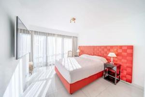 - une chambre avec un grand lit et une tête de lit rouge dans l'établissement PACA Properties 7C2 - appartement 3 chambres, à Cannes