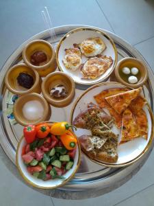 a tray with plates of food on a table at צימרים סוף העולם 3 in Ein Kinya