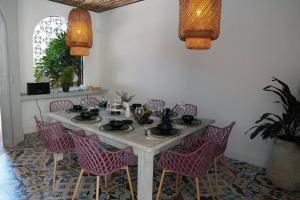 une table blanche avec des chaises roses et un mur blanc dans l'établissement Nueva en San Antonio Cali, La casa de Toña, à Cali