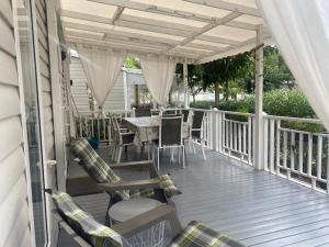 weranda ze stołem i krzesłami na tarasie w obiekcie Mobil Home Valras Plage w mieście Valras-Plage