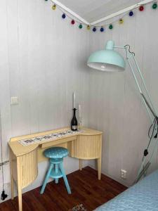 a desk with a blue stool and a lamp in a room at Frittliggende hytte i flott turterreng in Molde