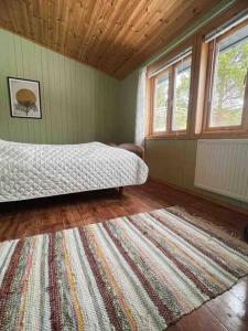 1 dormitorio con cama y alfombra en el suelo en Frittliggende hytte i flott turterreng en Molde