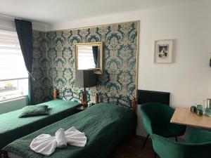 una camera d'albergo con due letti e uno specchio di Ubytování U Synagogy Dobříš a Dobříš