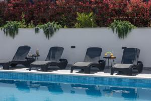 a group of chairs sitting next to a swimming pool at Villa Barbara & Zoran with heated swimming pool in Seget Vranjica