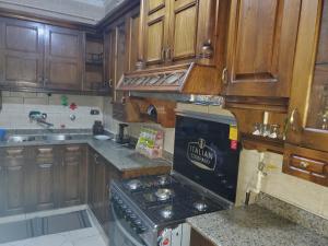 cocina con armarios de madera y horno con fogones en Mena Apartment, en El Cairo