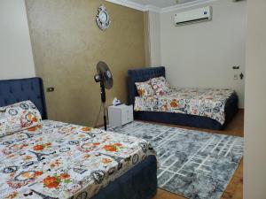 1 dormitorio con 2 camas y ventilador en Mena Apartment, en El Cairo