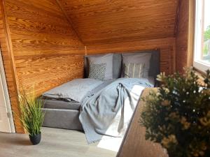 a bed in a room with a wooden ceiling at Strandhaus JP in Maasholm