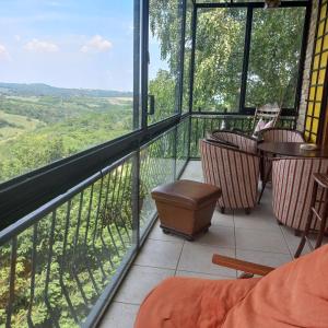 uma varanda com cadeiras e vista para o campo em Lodging Vidmar em Sremski Karlovci