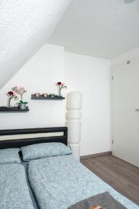 1 dormitorio con cama y pared blanca en modern house with pool - 3 bedrooms 2 Bathrooms, en Memmingen