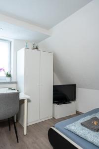 1 dormitorio con armario blanco y escritorio en modern house with pool - 3 bedrooms 2 Bathrooms, en Memmingen