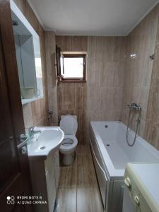 een badkamer met een toilet, een wastafel en een bad bij Apartment Savkovic in Šipovo