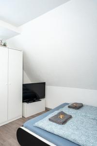 a bedroom with a bed and a flat screen tv at modern house with pool - 3 bedrooms 2 Bathrooms in Memmingen