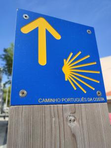 a blue and yellow sign on a wooden pole at Balada dos Mares Vila in Vila do Conde