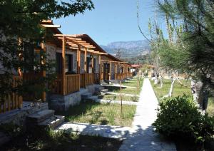 Une rangée de cottages avec des montagnes en arrière-plan dans l'établissement Begonvillage Tatil Evleri, à Datça