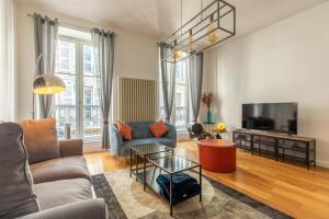 a living room with a couch and a tv at MONT CERVIN Standing & Central in Clermont-Ferrand