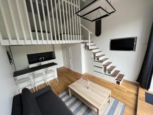 sala de estar con escalera y mesa en Alyvų Namai Nida, en Nida
