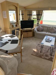 a living room with a couch and a table at Ingoldmells, Coral beach, 8 birth in Ingoldmells