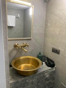baño con lavabo de oro y espejo en Center Lviv Avenue 23 en Leópolis