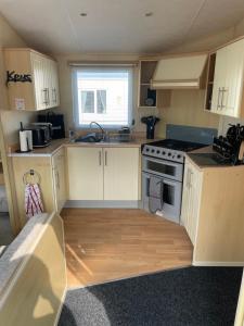 a small kitchen with a sink and a stove at Ingoldmells, Coral beach, 8 birth in Ingoldmells