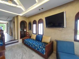 a living room with a couch and a flat screen tv at Beach House in KSAR RIMAL in Marina Smir