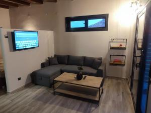 mosquito Luxury Studio في كيراموتي: غرفة معيشة مع أريكة وطاولة قهوة