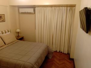 a bedroom with a bed and a window with curtains at Mi primer logro in Buenos Aires