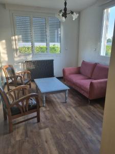 a living room with a couch and a table and chairs at Chambre dans maison à partager in Talensac