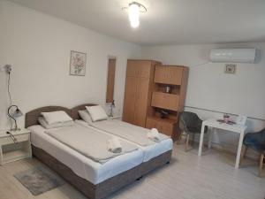 a bedroom with a large bed and a table and chairs at Veronika Rooms in Hévíz